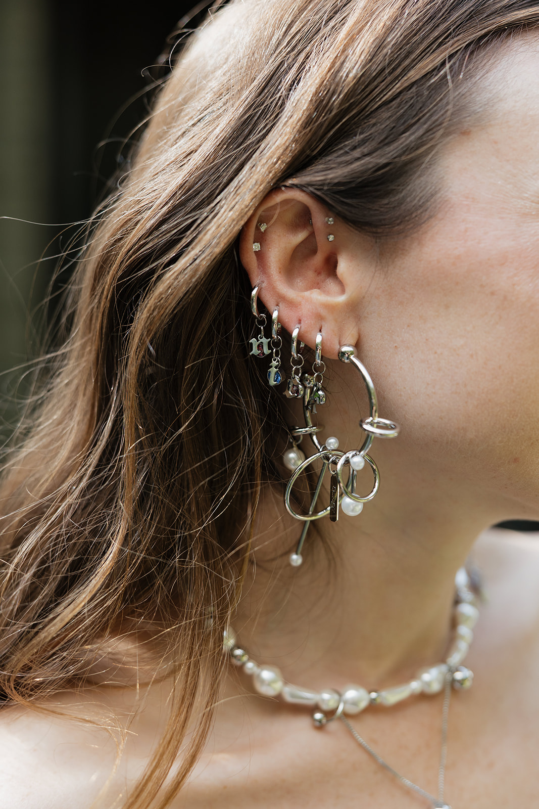 Detail photo of the bride’s statement earrings spelling Nick during a stylish wedding at The Mod House in Ellenville, NY.