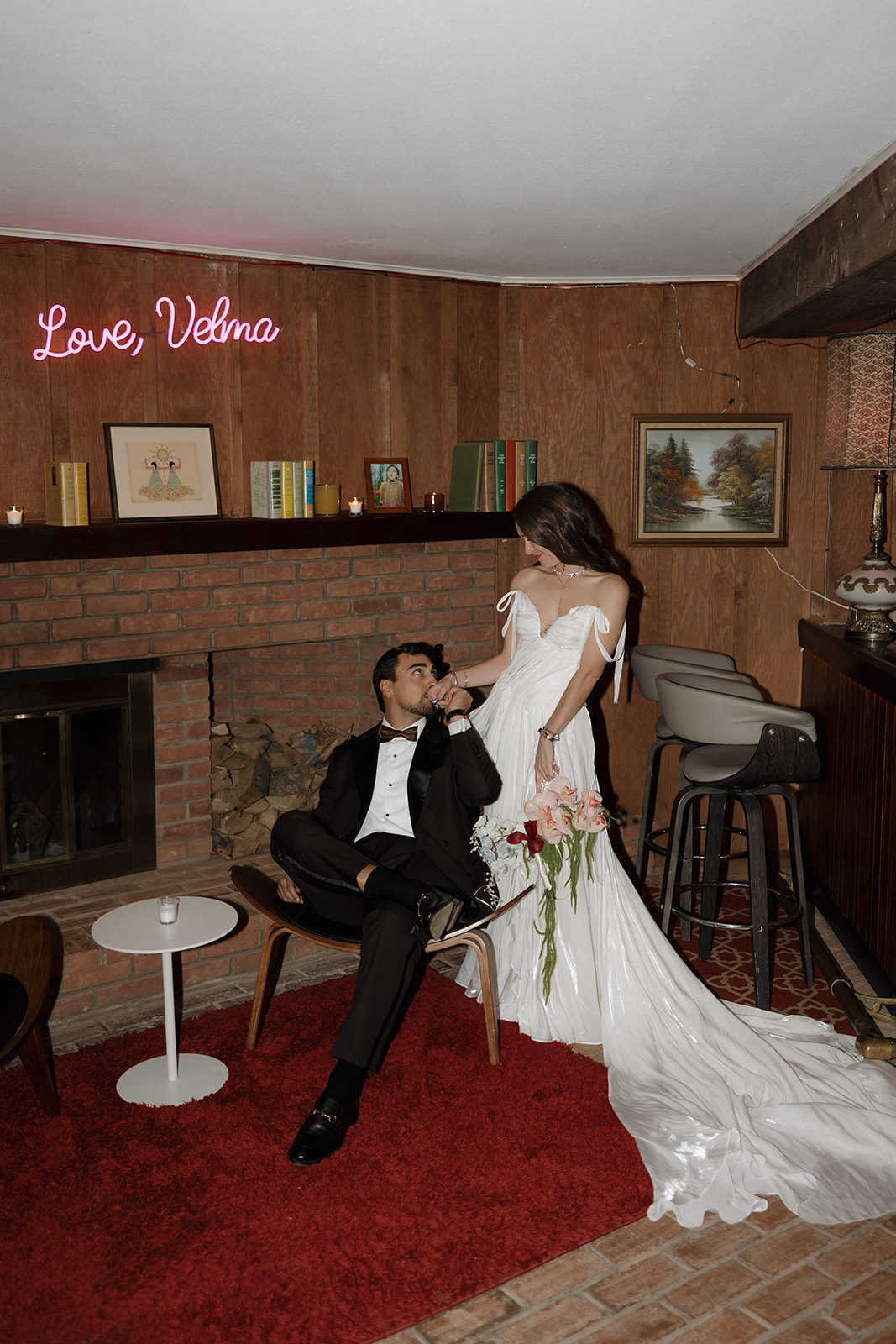 Stylish indoor wedding portrait with retro furniture and wood-paneled walls at The Mod House in Ellenville, NY.