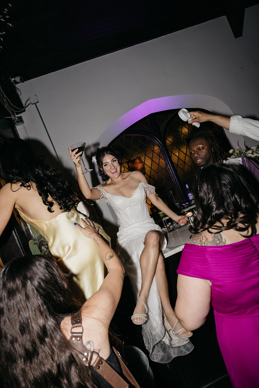 Bride raising a glass on a bar during the reception