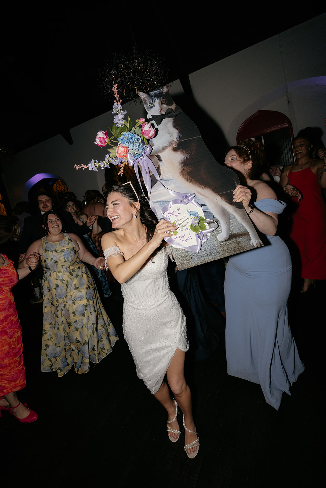 Bride raising a life size cat cutout during her NYC wedding reception