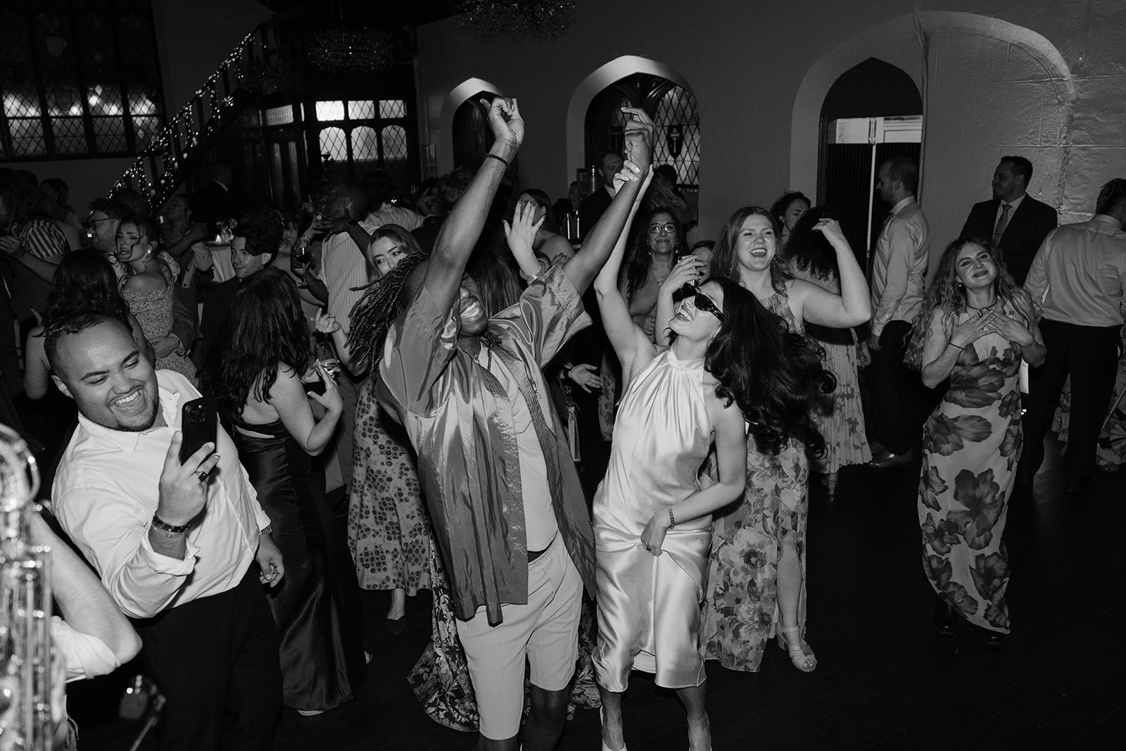 Black and white photo of wedding guests on the dance floor