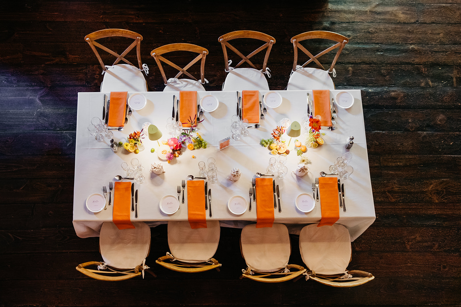 Overhead view of long reception tables with orange runners and vibrant centerpieces inside The Barns at Wesleyan Hills CT wedding venue.