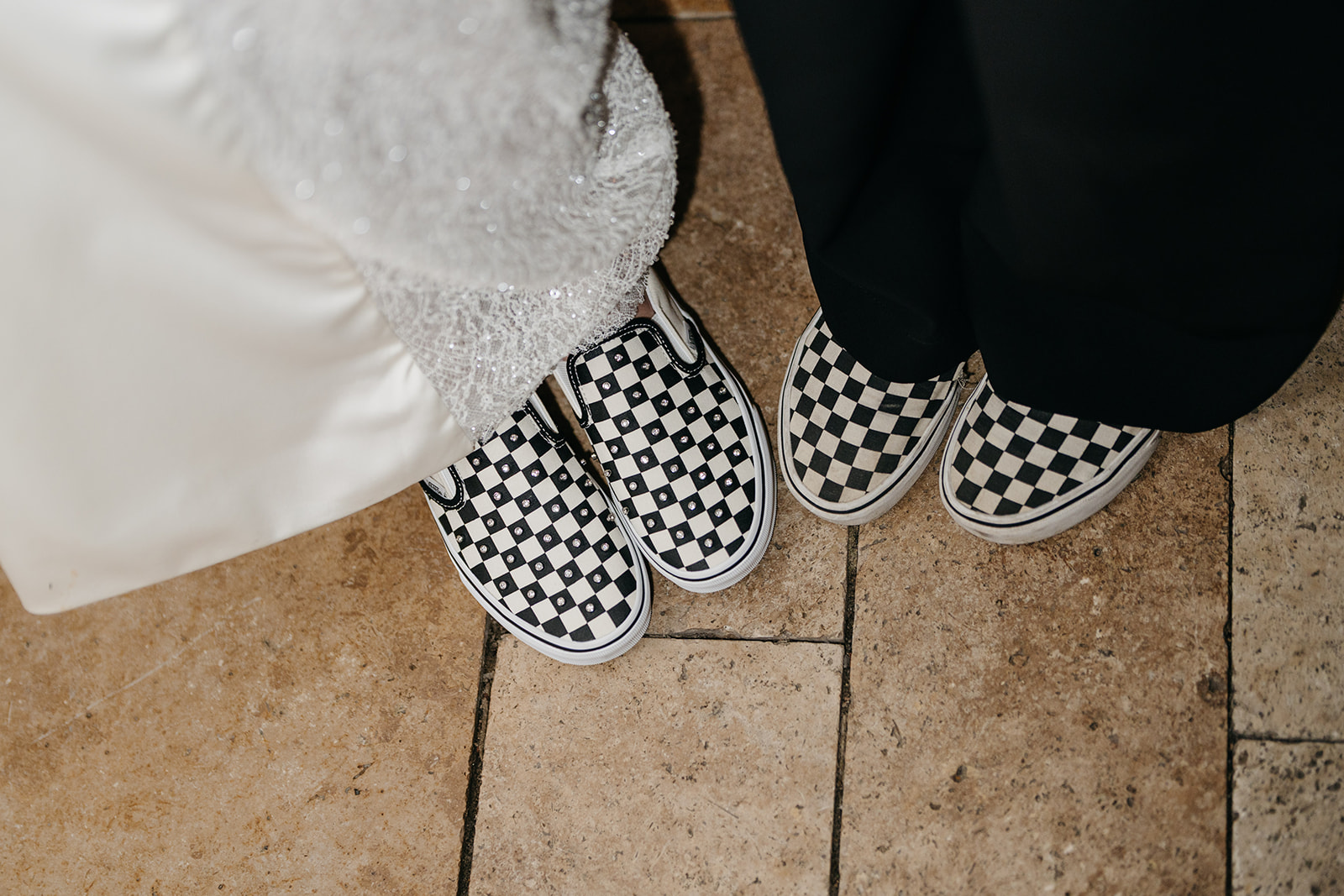 Bride and groom wearing matching black and white checkerboard Vans sneakers during their Chicago wedding reception