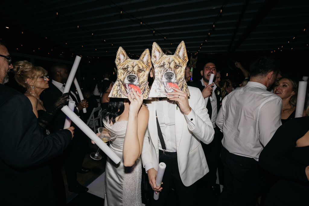 Guests dancing and wearing playful dog masks on the dance floor during a lively Galleria Marchetti wedding reception