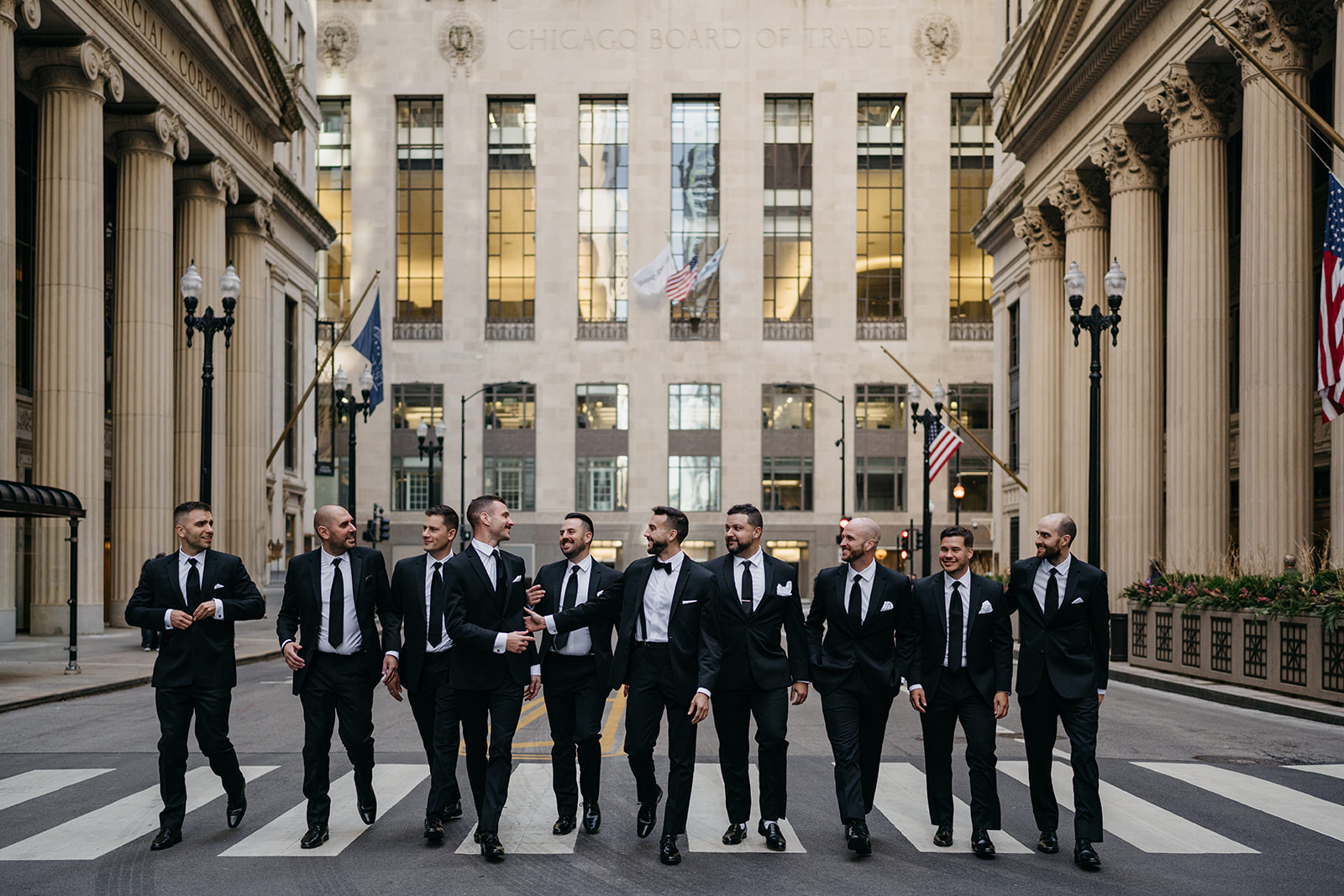 Groomsmen walking together down a Chicago street in matching black suits during Chicago Union Station wedding portraits