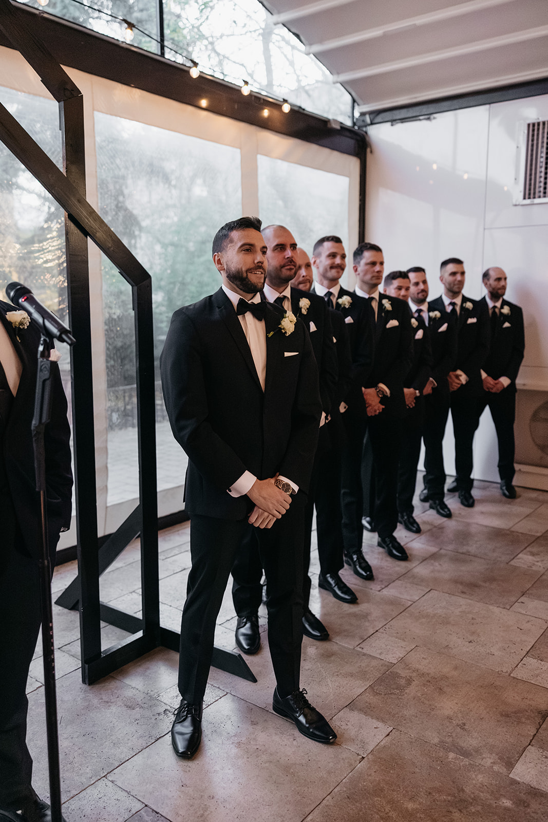Groom and groomsmen standing together during the wedding ceremony waiting for the bride