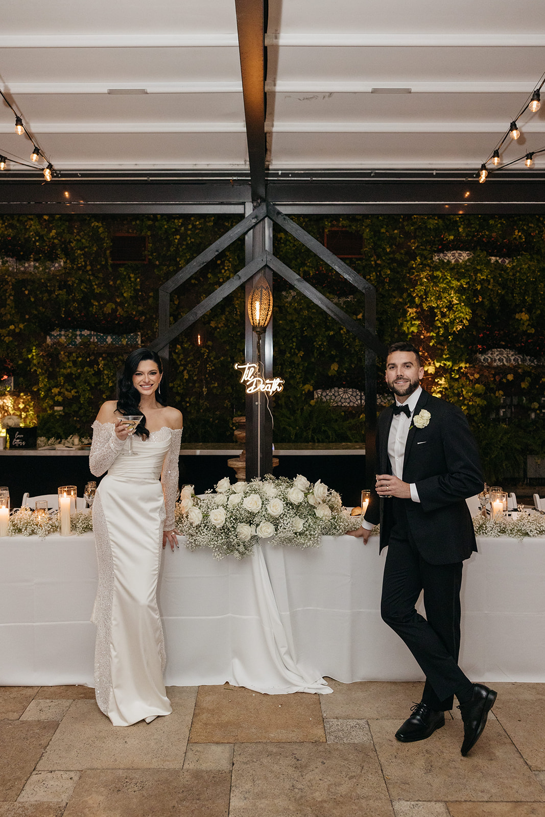 Bride and groom posing at their sweetheart table during their elegant Galleria Marchetti wedding reception