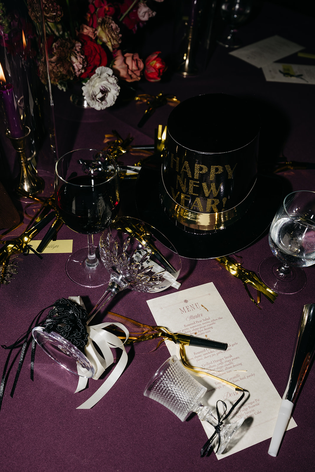 New Year’s Eve wedding table details with party hats, confetti, and menu styling