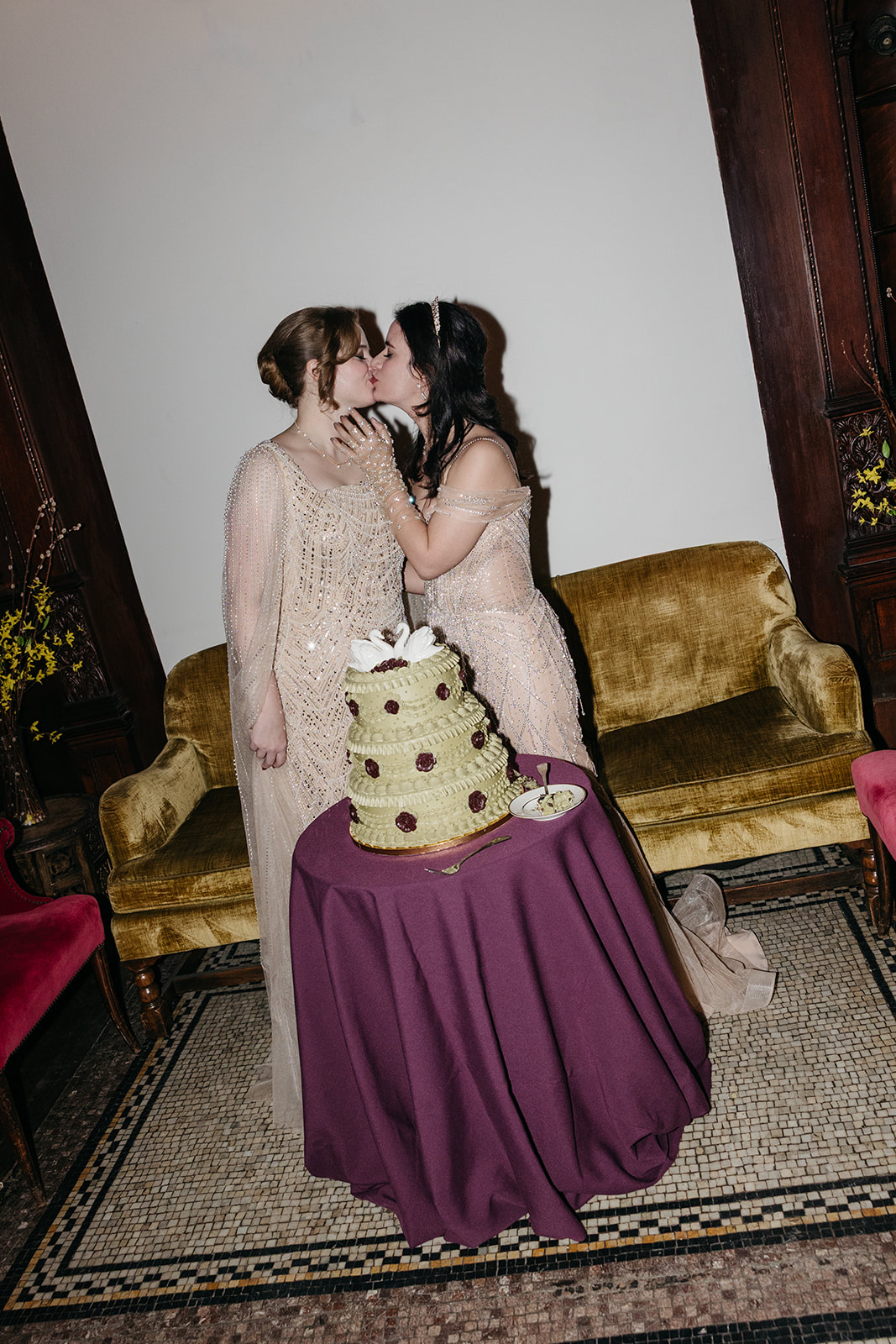 Couple kissing beside vintage wedding cake with purple linens at Montauk Club NYC wedding
