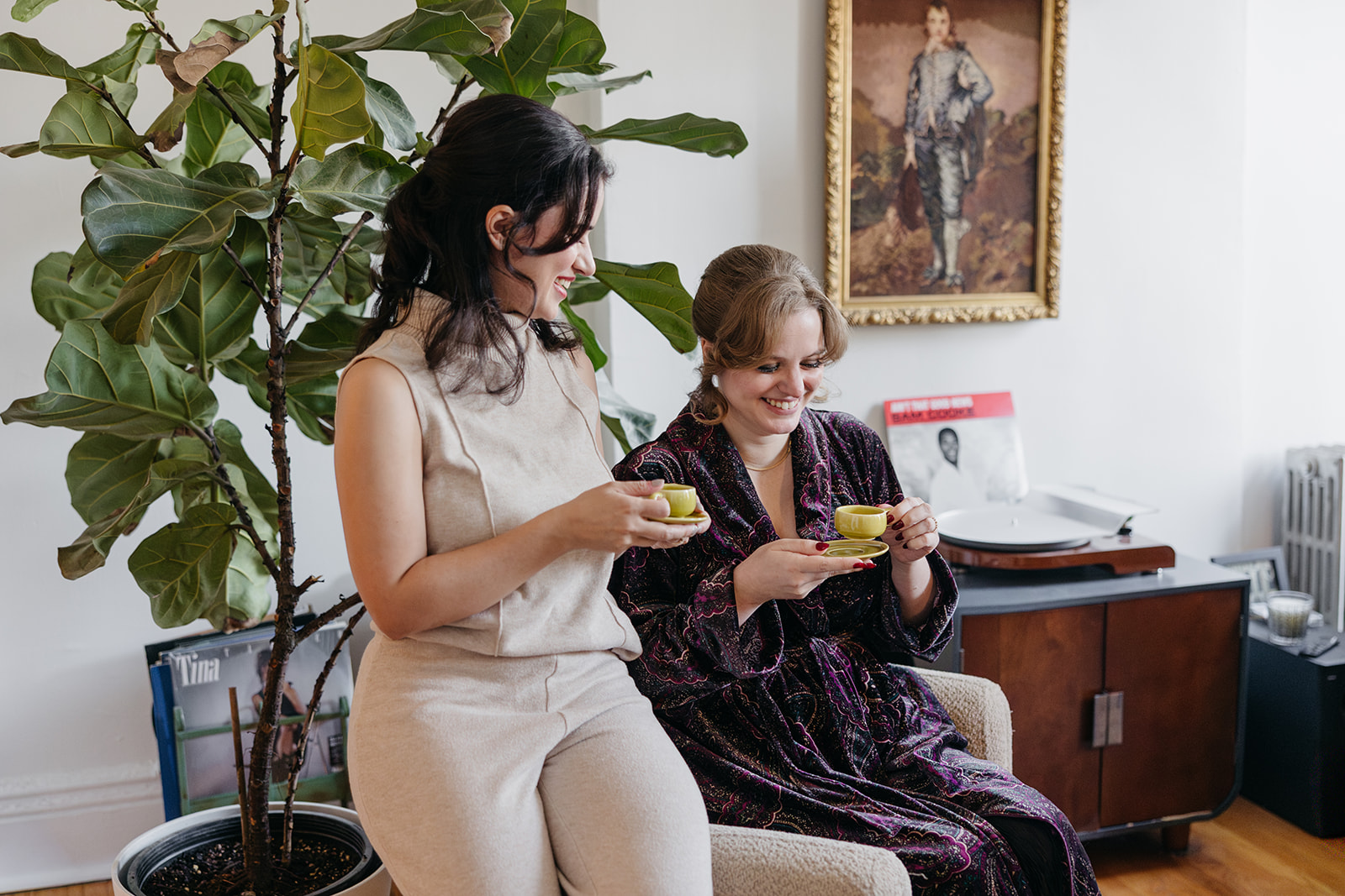 Couple laughing together while drinking espresso in Brooklyn apartment before wedding