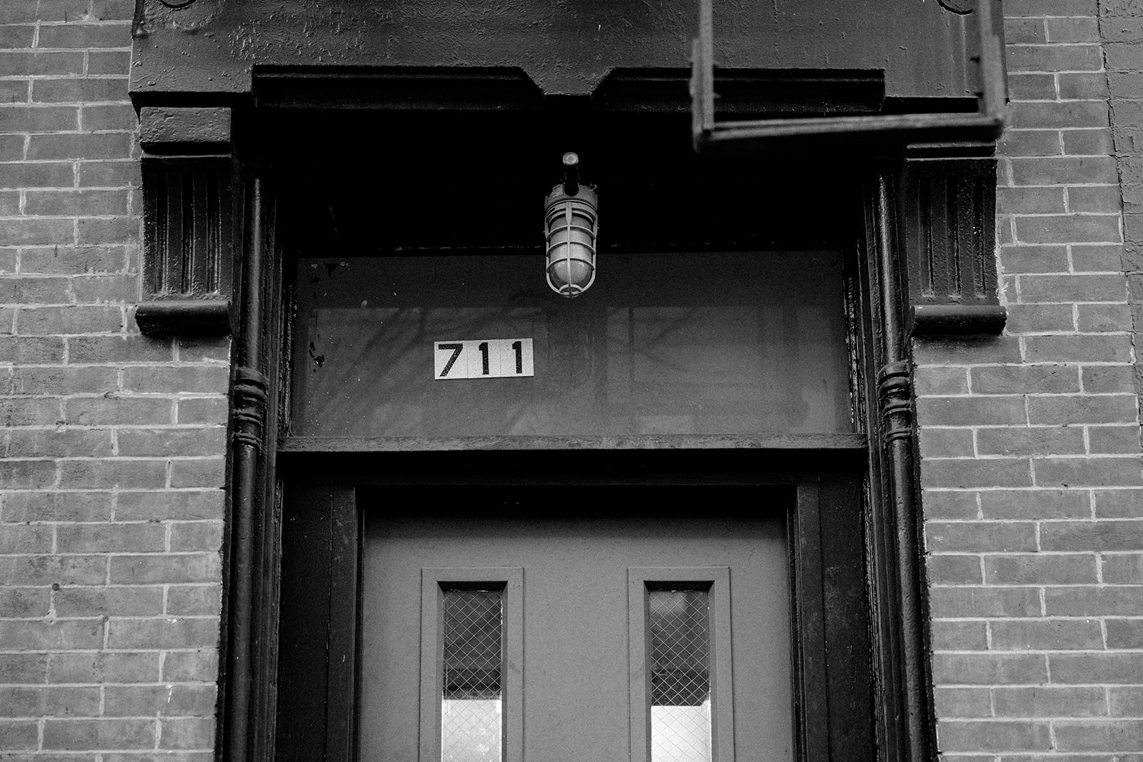 Black and white exterior of Brooklyn building entrance with 711 address, classic New York wedding setting
