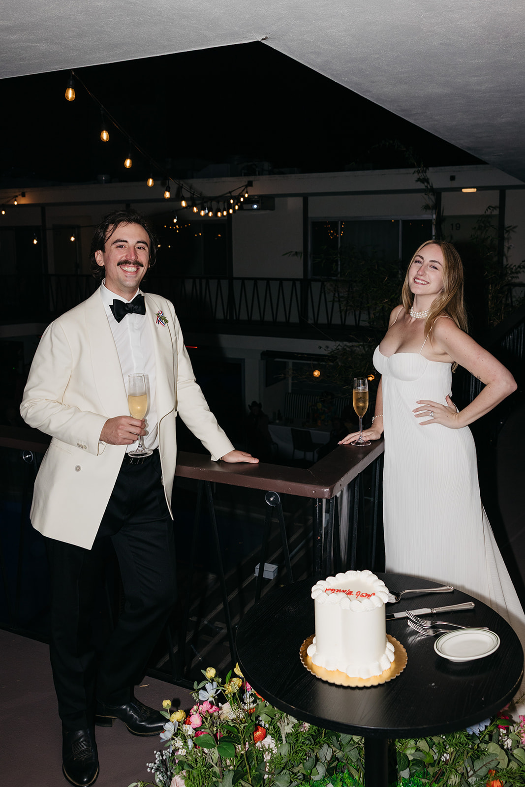 Bride and groom celebrating with champagne on balcony, modern San Diego wedding photography