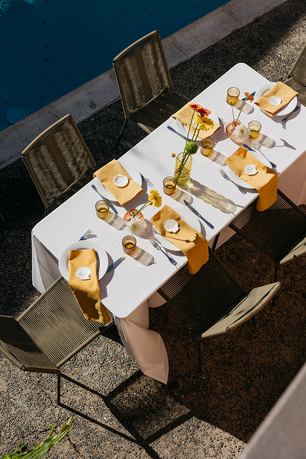 Overhead view of outdoor reception table with yellow linens and floral centerpieces in san diego