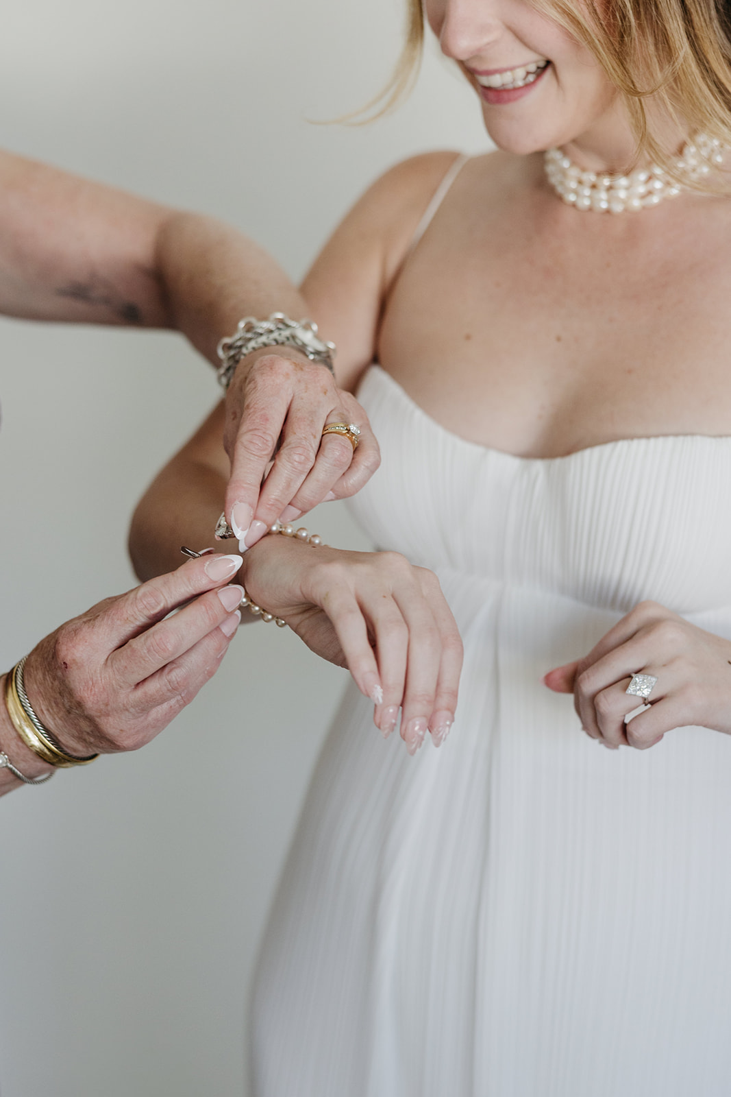 Close up of bride getting ready with bracelet and wedding rings detail