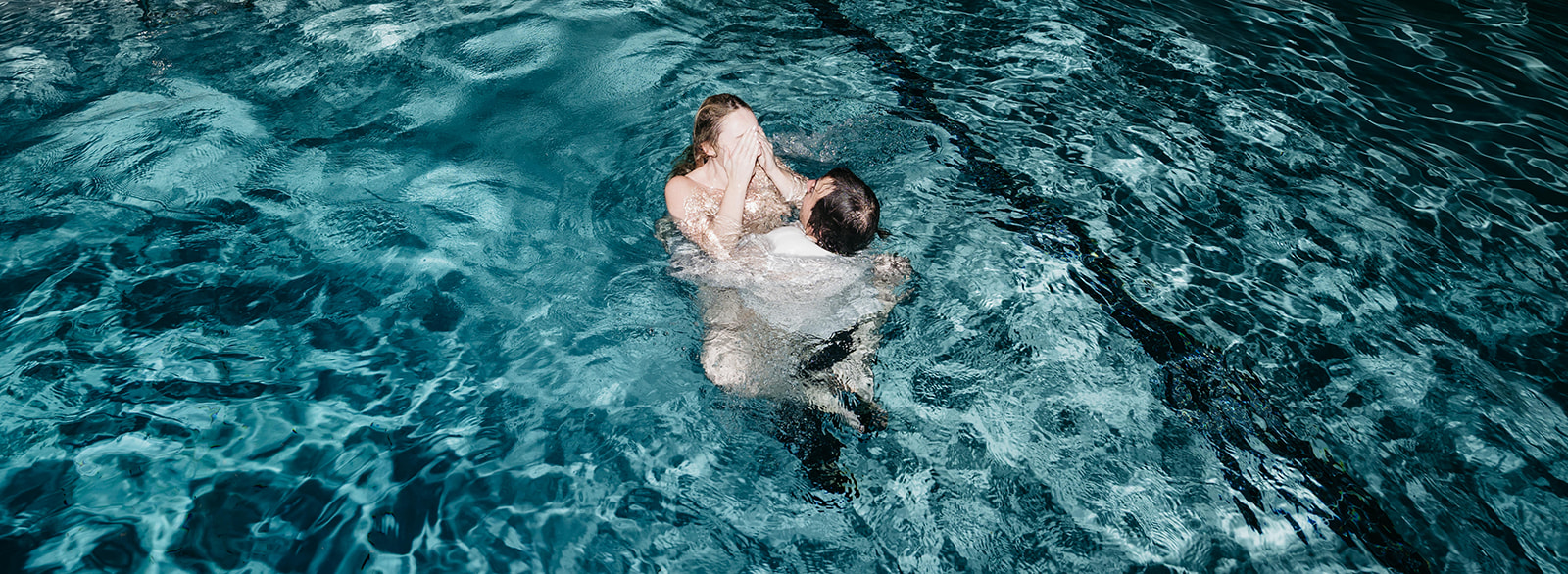 Overhead view of couple in water sharing intimate moment, modern San Diego wedding photography