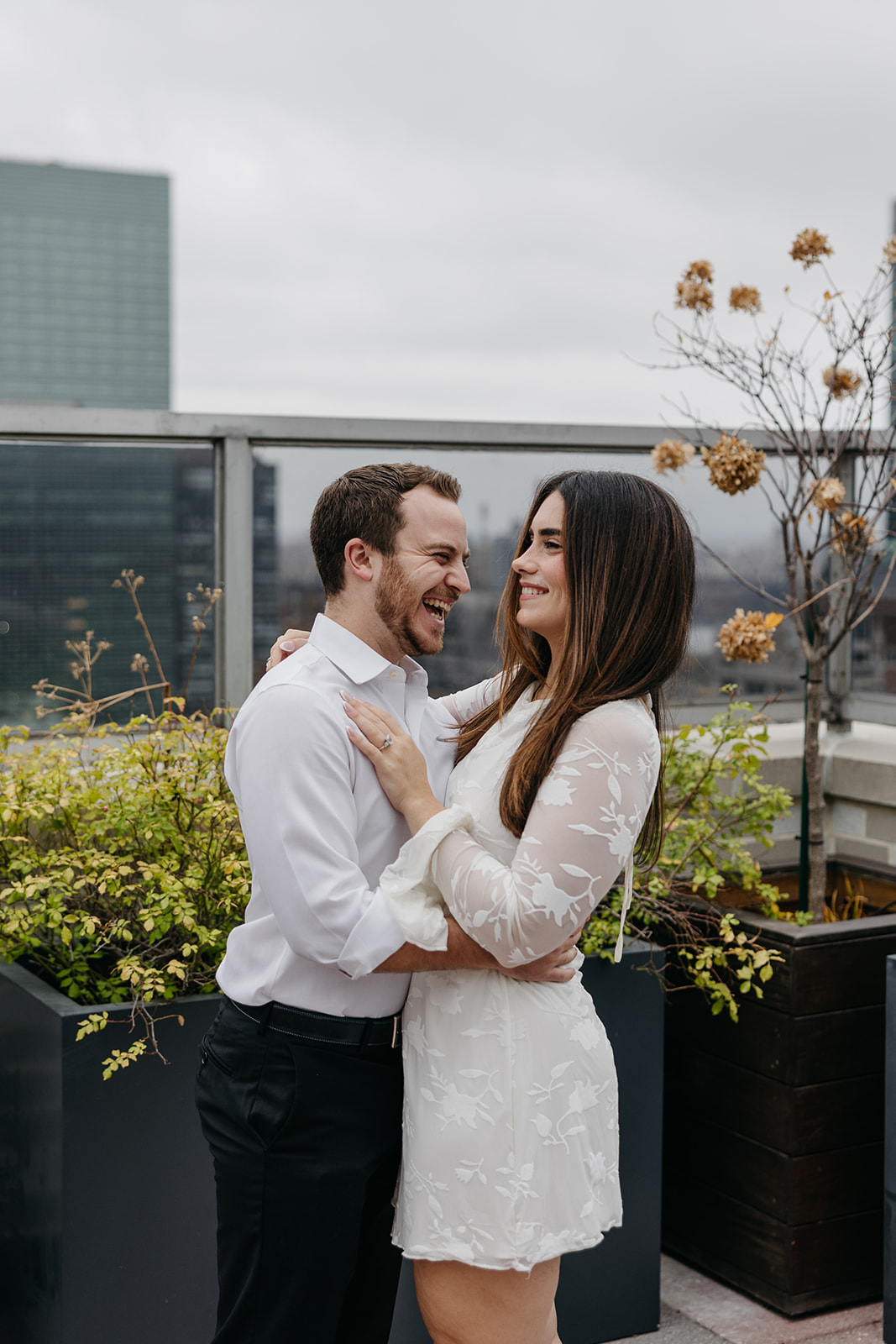Couple laughing together during rainy engagement shoot in NYC