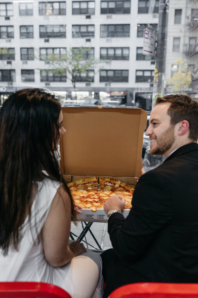 Nyc couple looking at each other over pizza